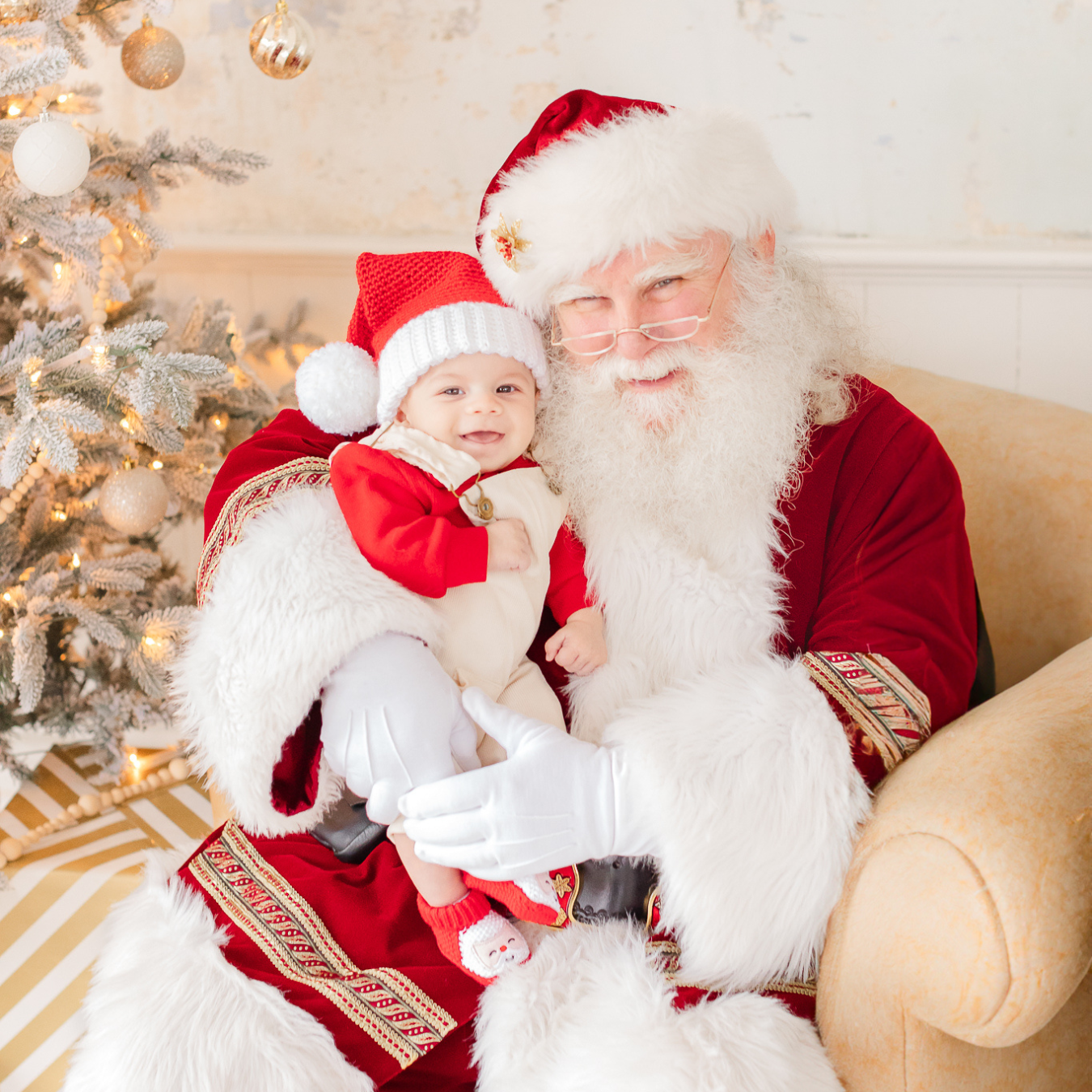 smiling baby sits on santa's lap