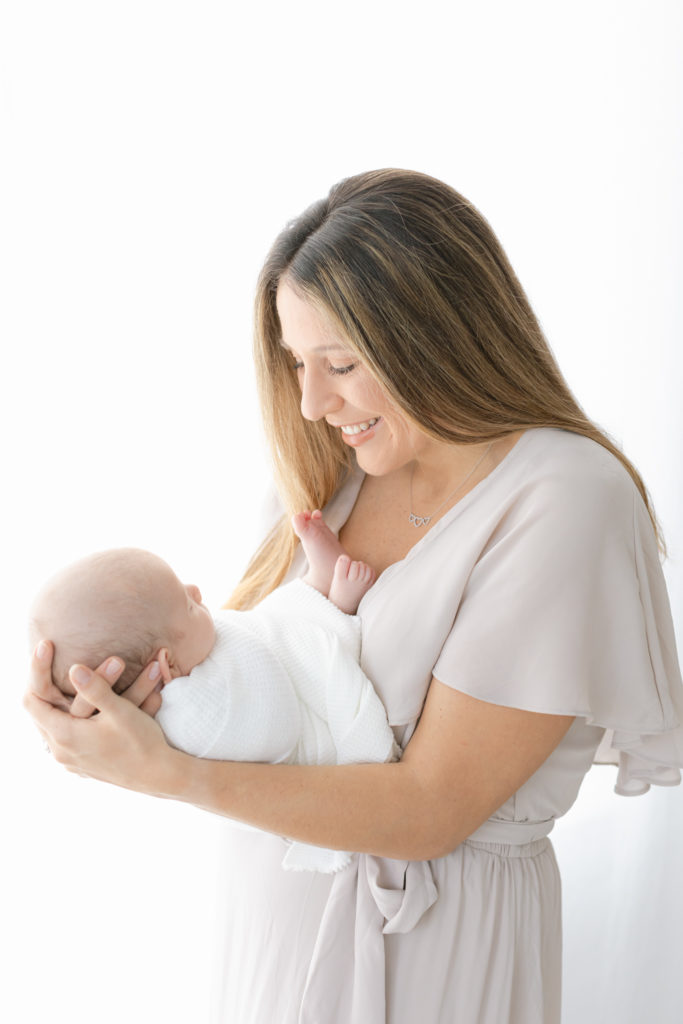 photograph of mom holding baby to chest smiling