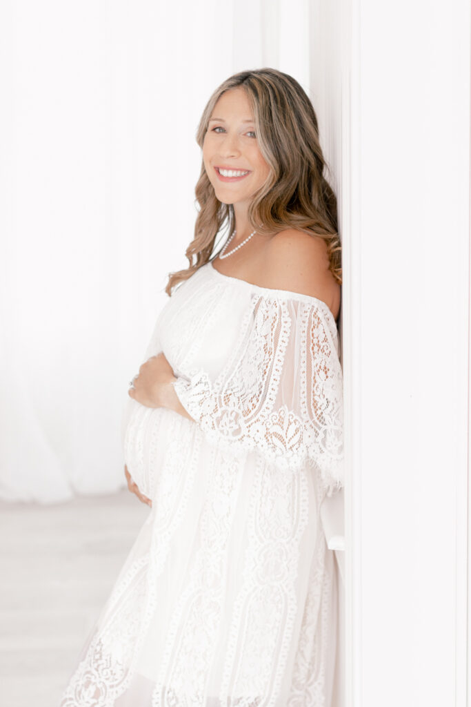 pregnant mom smiling holding her baby bump