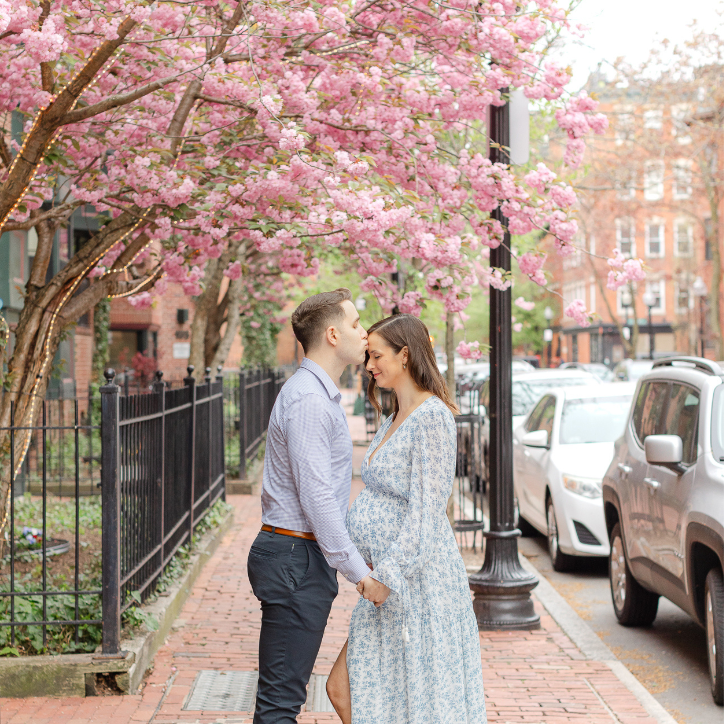 couple expecting their first baby pose together on downtown Boston street in the Springtime.