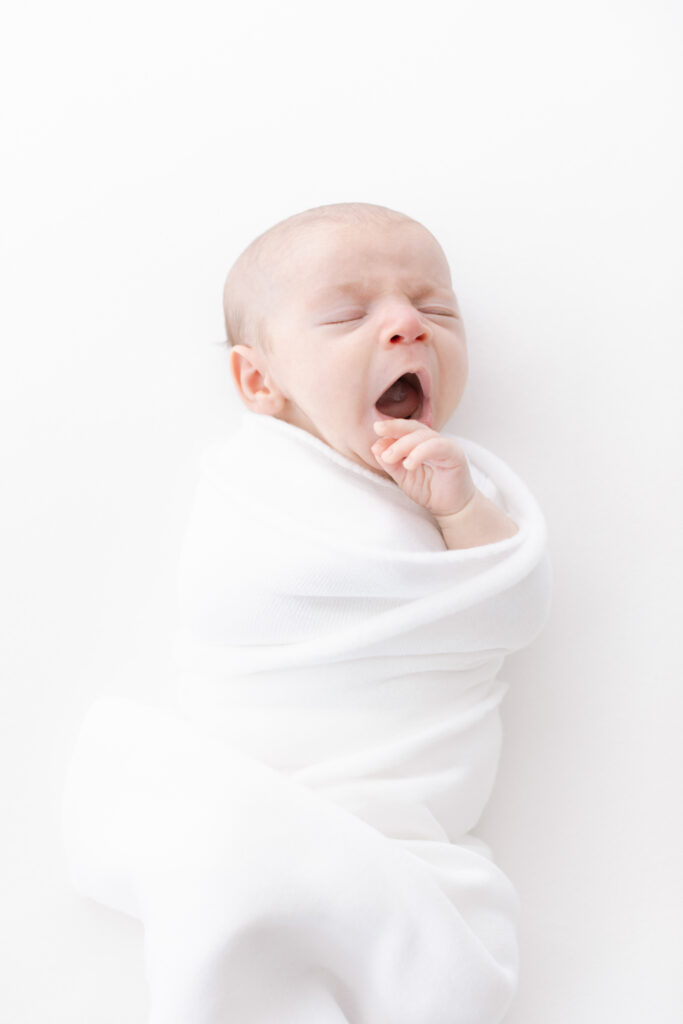 boston newborn baby swaddled and yawning