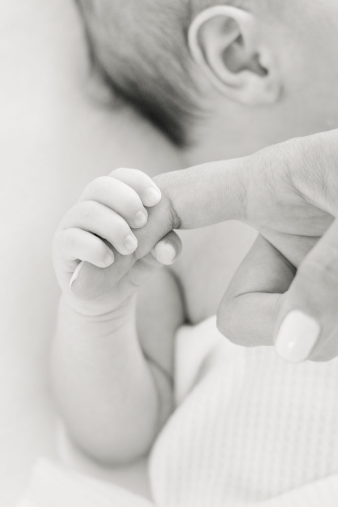 newborn grasps moms finger