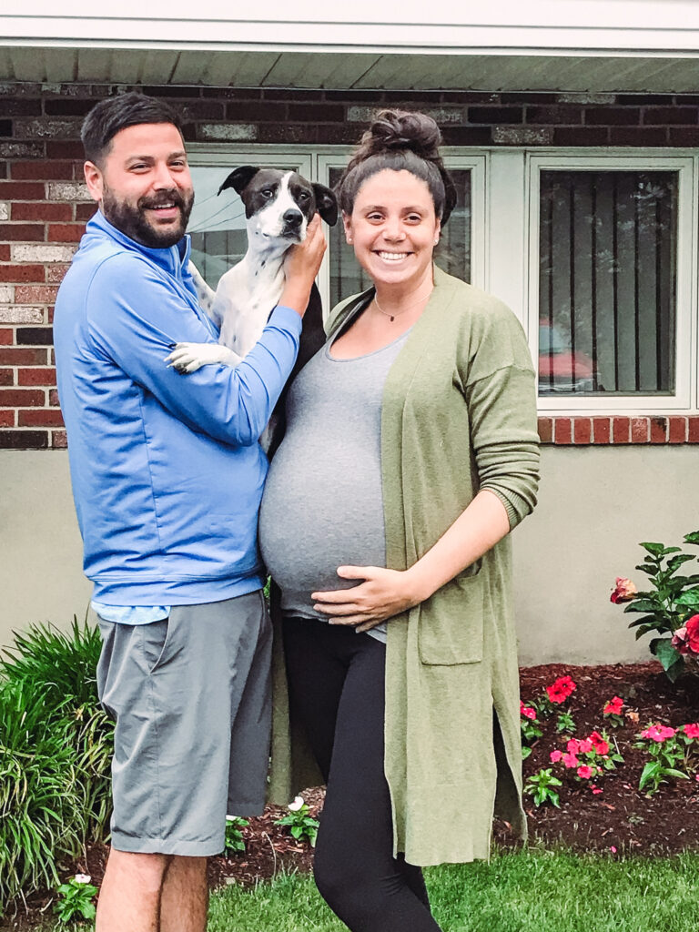 family of 3 posing with mom pregnant