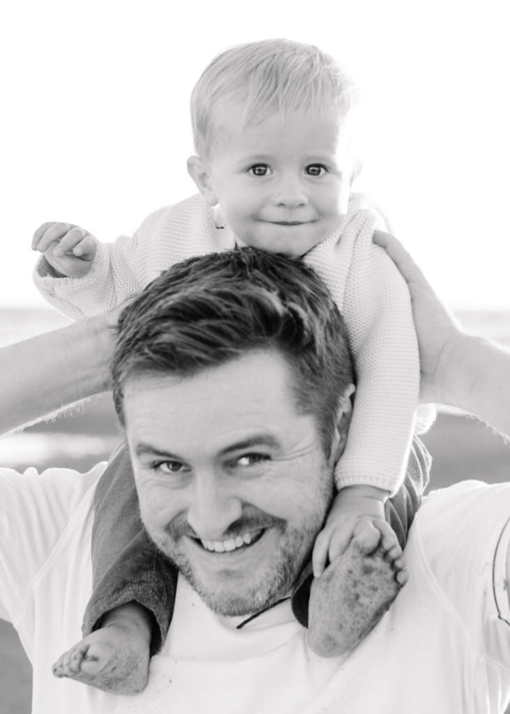 black and white image of dad and son at the beach